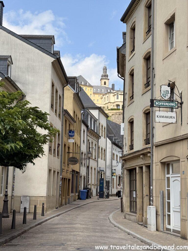Narrow cobblestone street in Luxembourg's Grund district lined with historic stone houses, a UNESCO World Heritage Site dating to the 14th century