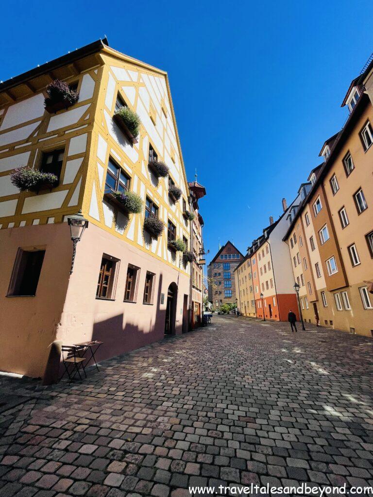 Colorful half-timbered building with flower boxes on cobblestone street in Nuremberg's historic old town (Altstadt), Bavaria, Germany