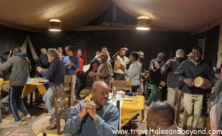 Families dining together in Tanzania safari camp tent after evening game drive