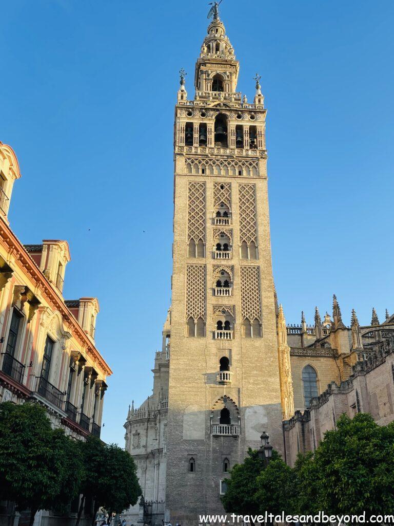 The Giralda bell tower of Seville Cathedral rising against a blue sky in the historic center of Seville, Andalusia, Spain