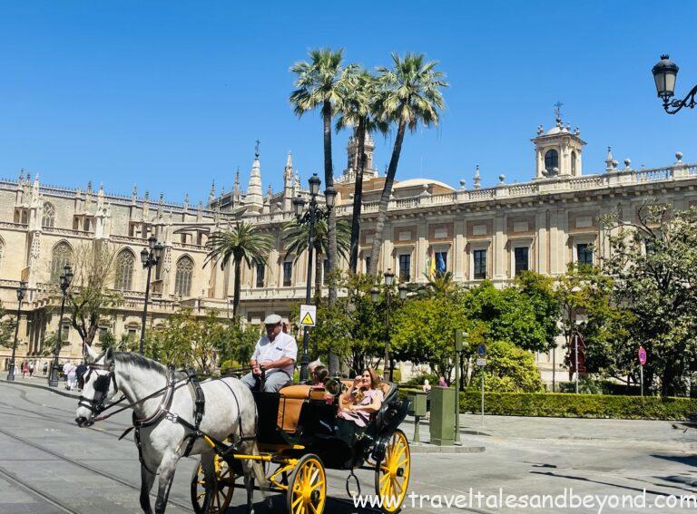 Horse-drawn carriage passing in front of Seville Cathedral and the General Archive of the Indies, Seville, Andalusia, Spain