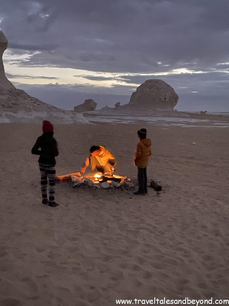 Sunset over a desert camp with bonfire in Egypt's White Desert